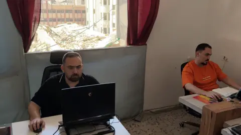 Co-working space for high-tech workers in Gaza City, with the rubble of destroyed buildings in the background