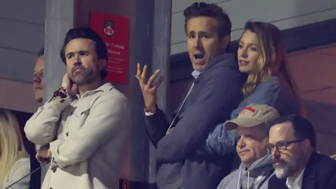 Pained expressions on the faces of Rob Mac, Ryan Reynolds and Blake Lively as they watch Wrexham lose to Chelsea in a cup match last month