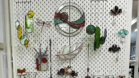 Glass Apple Studio A selection of glass sculptures, hanging on a wall