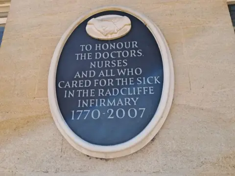 BBC/Molly Pipe A black stone plaque reads "To honour the doctors and nurses and all who cared for the sick in the Radcliffe Infirmary 1770-2007".
