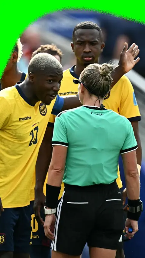 Ecuador players protest to the referee