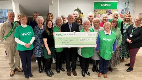 Group of volunteers holding a check for £1m