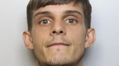 Jordan Dutton, who has short brown hair, brown eyes and a short goatee beard.