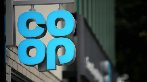 A blue 'COOP' sign at the top of a shop.