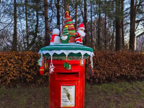 Richard Webber Festive knitting of a tree, elf, snowman and Santa on top of a postbox.