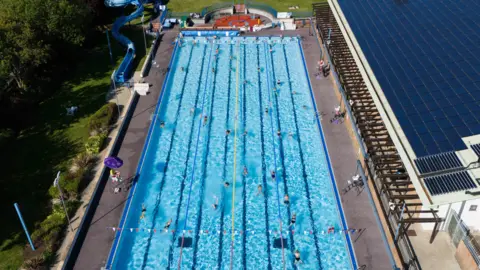 People swim at Banbury Lido at Woodgreen Leisure Centre in Oxfordshire.