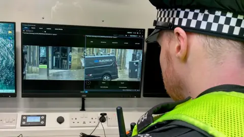 The back of a policeman's head looking at two monitors inside the Facial Recognition