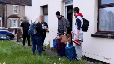 Heidi and her sons outside the property talking to bailiffs