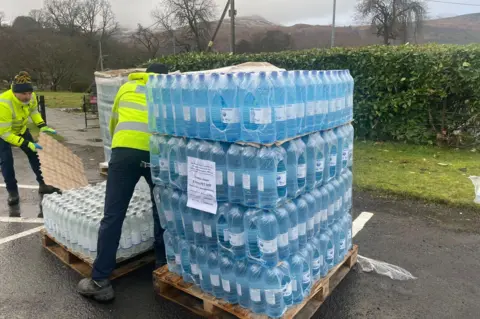 Scottish Water Two men unloading a pallet of bottled water