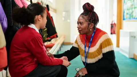 A mental health support worker comforts a primary school child
