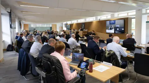 A group of people sat in a conference room.