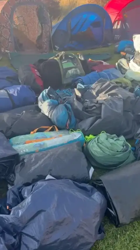 Emily Crichton Tents, sleeping bags and camping equipment laid out on the ground outside