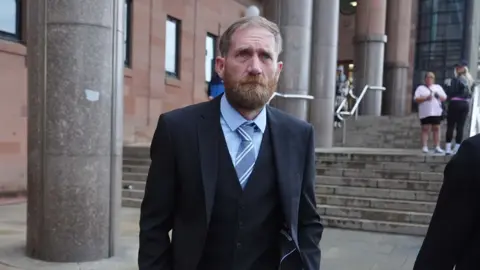 PA Media Bearded Daniel Graham, wearing a suit and tie, leaves Newcastle Crown Court.