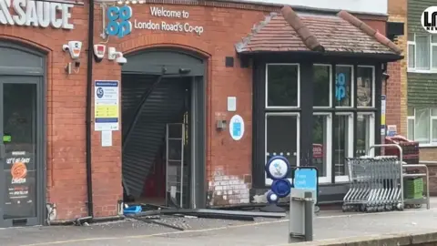 The smashed shutters at the front of a Co-op store