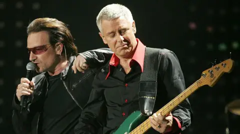 Bono and Adam Clayton of U2 perform on stage in 2005