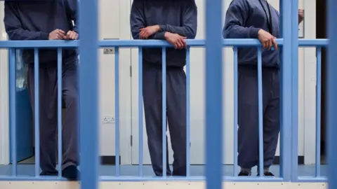 Corbis/Getty Images Young offenders hang outside their cells