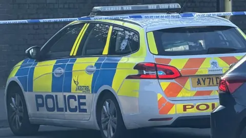 A police car blocking Ranelagh Road. Police tape can be seen behind