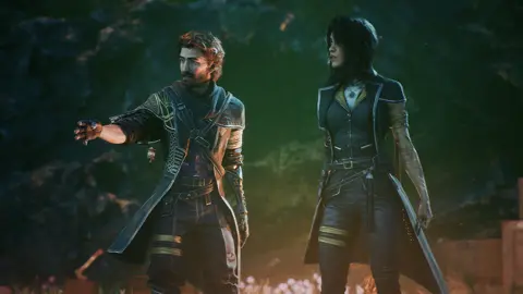 Screenshot shows a bearded male character and a female companion, both wearing leather-effect outfits. They appear to be in some sort of cavern, with luminous plants emitting an eerie pink glow around them.