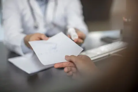 Getty Doctor giving patient a note - stock photo