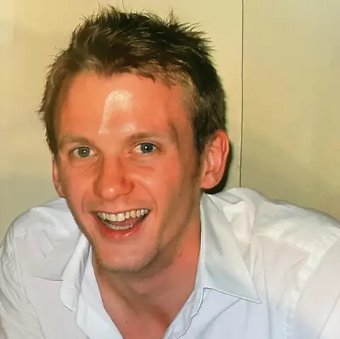 Joan Scourfield The photo shows James wearing a white shirt and smiling at the camera