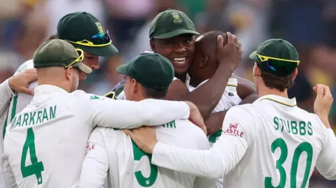South Africa bowlers Kasigo Rabada and Lungi Ngidi are mobbed by their team-mates after a wicket 