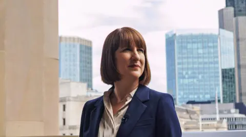 Getty Images Rachel Reeves with the City of London skyline behind her and an overcast sky