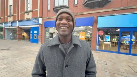 A potential voter is questioned about politics in Hull city centre.