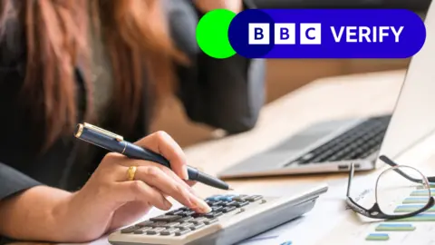 Getty Woman calculating her taxes