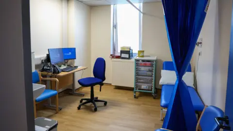 Gloucestershire Hospitals Trust A room in a clinic in a hospital with curtains around a bed