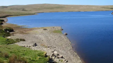 Tudur Davies A rocky beach reveals lower than average water levels at Llyn Aled Isaf reservoir on Mynydd Hiraethog in Conwy county.