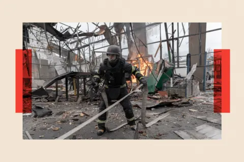 Global Images Ukraine via Getty Images Emergency service workers in Ukraine attend a fire at a hangar destroyed by a drone strike