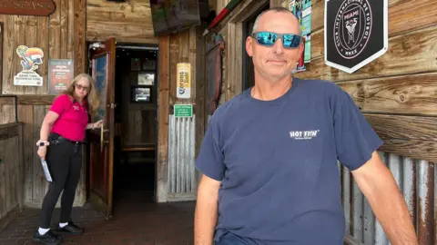 Shelby Stevens stands outside a bar.