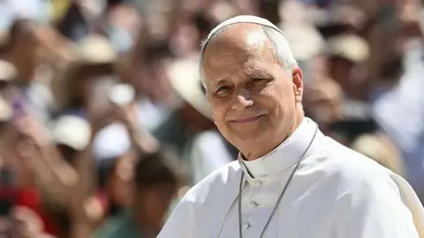Pope Leo, in his white papal robe and skullcap