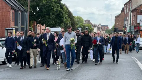 BBC The victims' families walking together