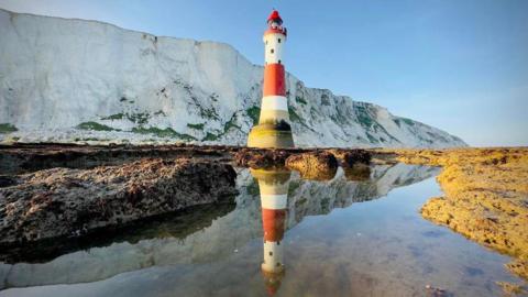 A light house reflecting in sea water 
