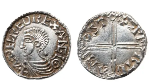 Colchester and Ipswich Museum Service Two views of a silver penny of Etheldred II, king of England, from AD978 to 1016. The view on the has a profile portrait of the king with a mass of hair like a long Mohican and wearing a tunic, pinned at the throat. His name is struck on its circumference. The right view is of a simple cross with the name of the maker and its date on its circumference.