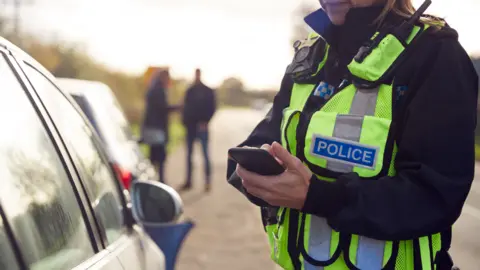 Getty Images A roads policing officer speaking to a driver