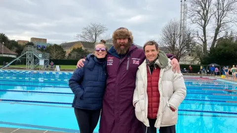 Left to right: Laura Nesbitt, Fenwick Ridley and Simon Griffiths standing in front of the pool