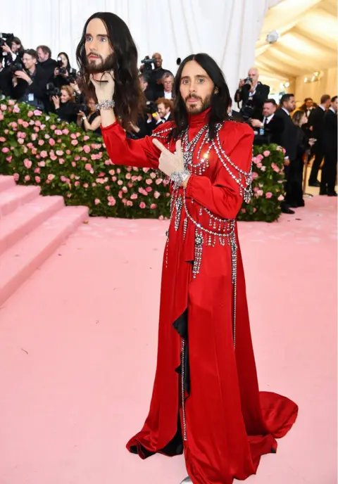 Getty Images Jared Leto holds up a model of his head