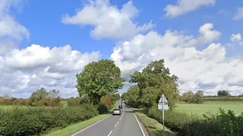 Google The A5199 with trees and bushes on either side of the road 