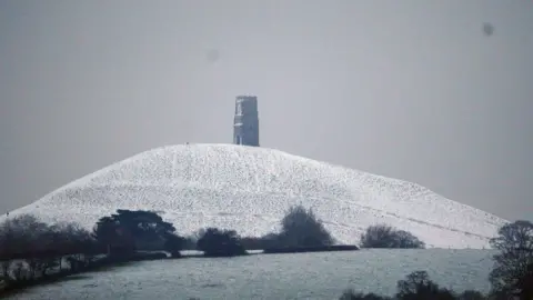 Ben Birchall/PA Wire Snow surrounds Glastonbury Tor in Somerset