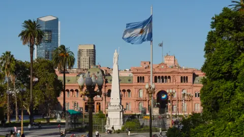The Plaza de Mayo square in the heart of Buenos Aires, with an Argentinian flag shown flying in the foreground