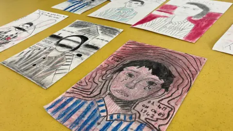 Jon Wright/BBC Stylised portraits of figures wearing concentration camp outfits drawn in charcoal. 