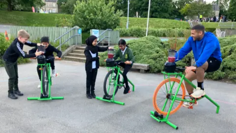 Tom Ingall/BBC Steel y algunos niños en bicicletas de batidos 