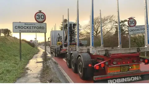 A wood lorry heading into a a 30 miles per hour zone at Crocketford in Dumfries and Galloway. 