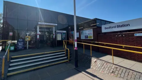 Steve Hubbard/BBC The front of Bedford Station with steps and an accessibility ramp leading to the glass fronted entrance.