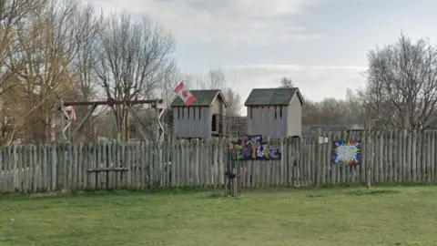 Google map still of The Venture centre in Wrexham. A wooden fence circles a wooden playground. 