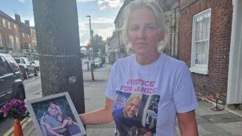 Adele Cook Woman with photo of husband and kids.
