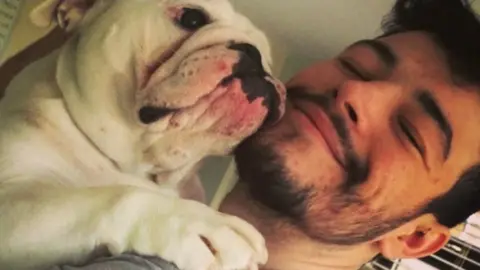 Family handout Rian Rogers cuddling with a dog