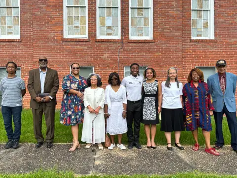 Brandon Drenon/BBC Parishioners stand for a photo outside Butler Chapel African Methodist Episcopal Zion Church in Tuskegee, Alabama